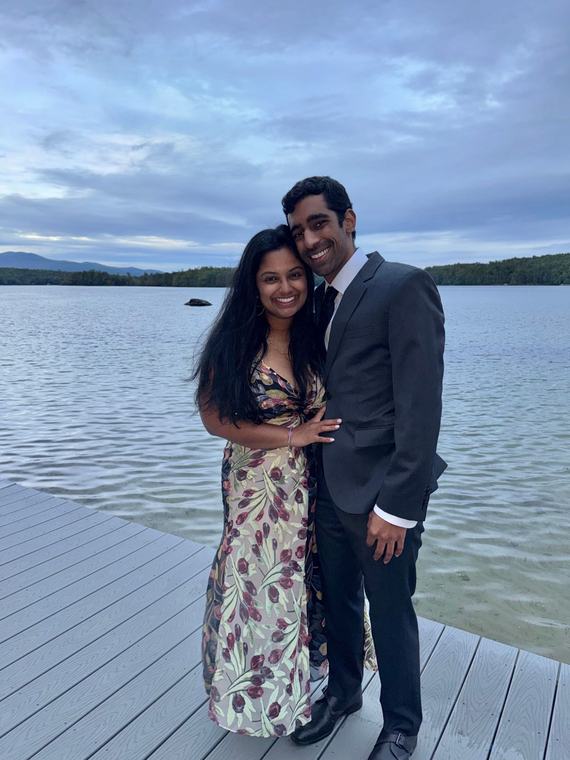 Manu and Nikhil on a dock by a lake at dusk